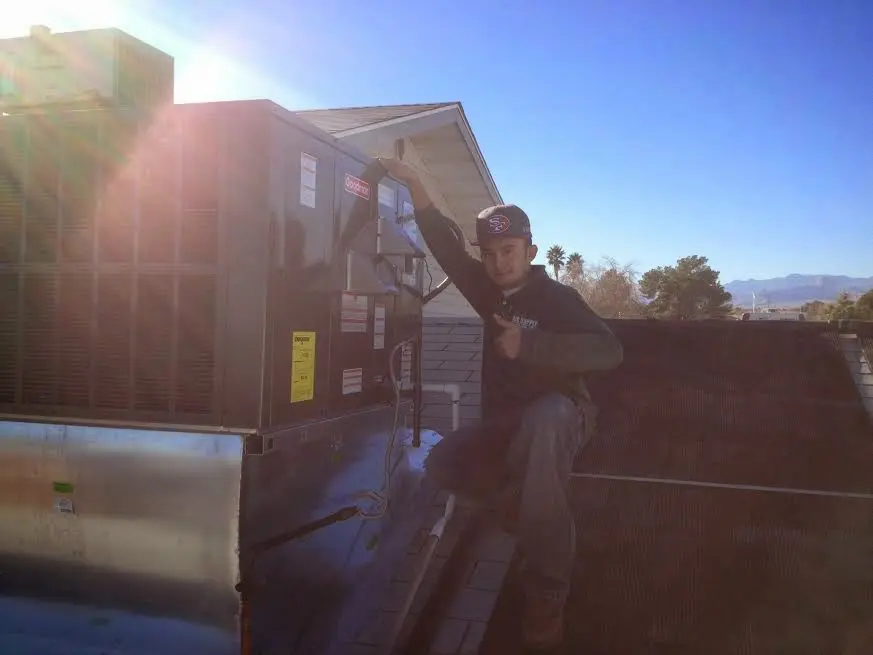 HVAC technician performing Heat Pump Repair on a rooftop unit in Annapolis